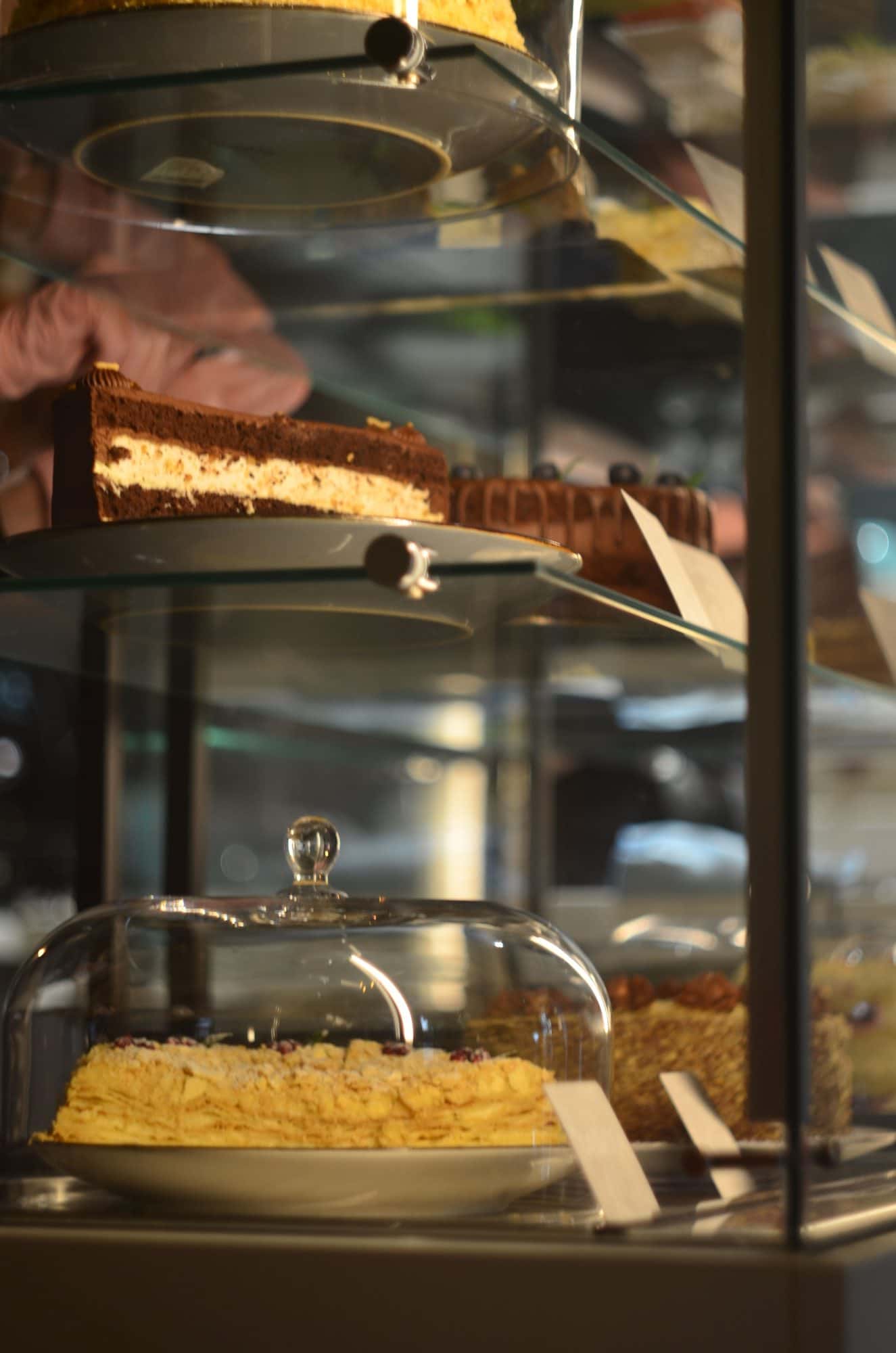 Gebak en cakes op glazen schappen in de bakkerijvitrine