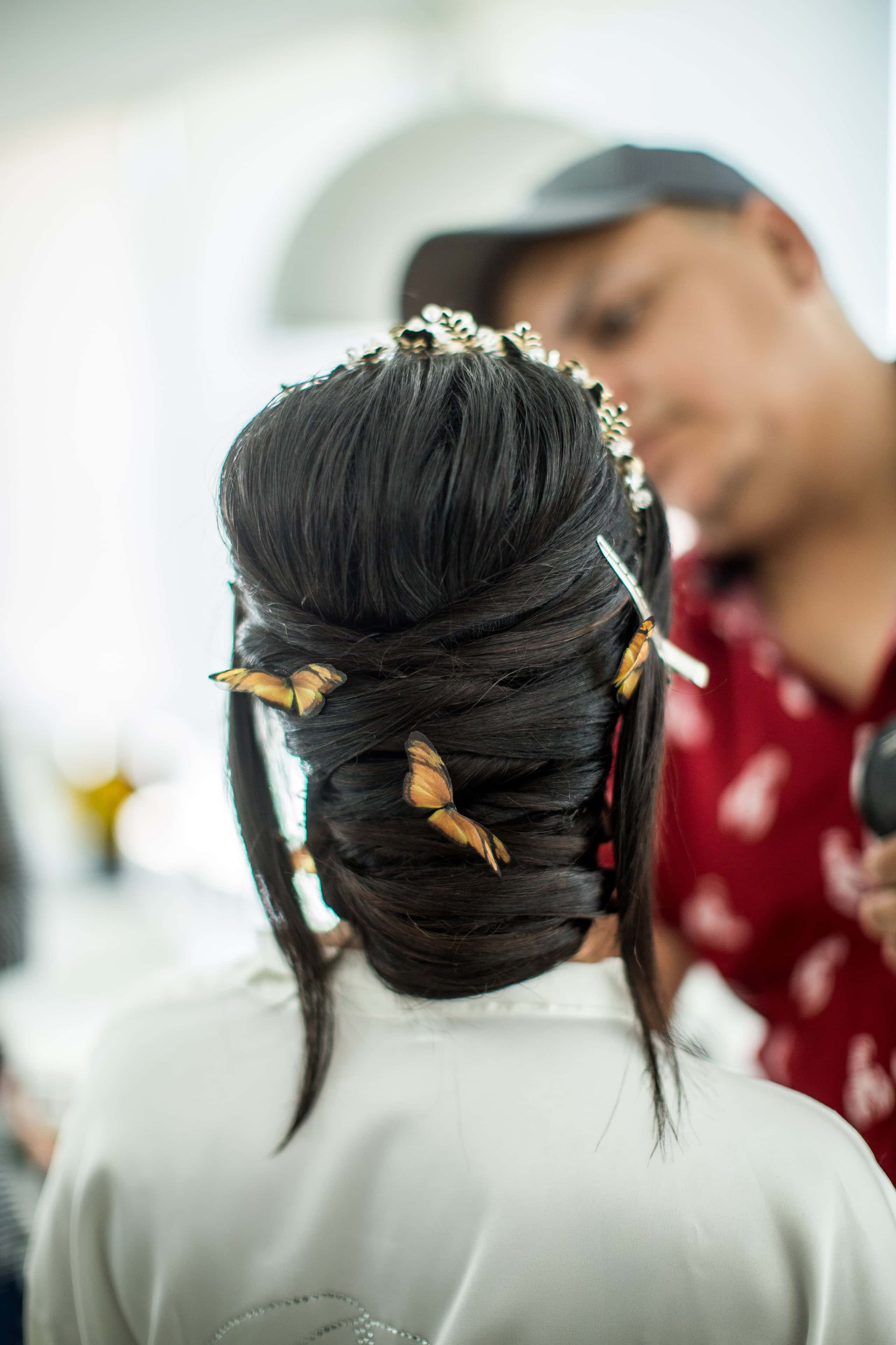 Bruid van achteren met een gevlochten opgestoken kapsel met haarsieraden
