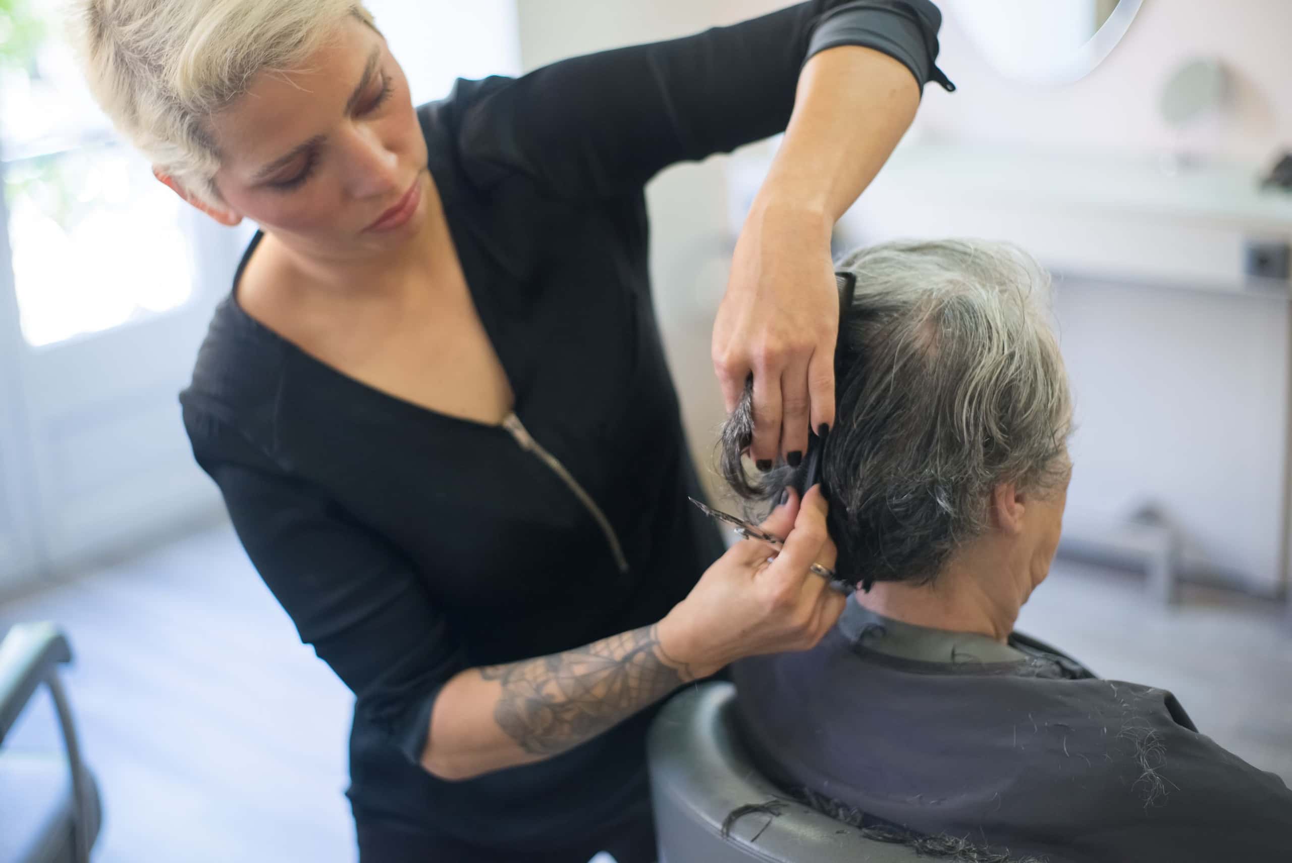 Stylist knipt het haar van een klant in een lichte salon